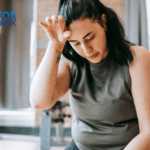 A woman looking exhausted and wiping sweat after an intense workout session at the gym, showing signs of physical fatigue.